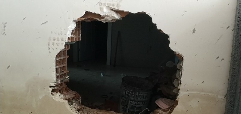 Ofisin yan tarafındaki daireye giren hırsızlar burada duvarı kırarak yaklaşık 30 santimetre çapında delik açtı.