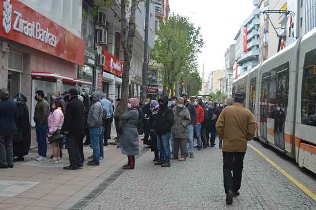 Eskişehir’de sokağa çıkma kısıtlamasının bitmesiyle birlikte vatandaşlaralar bankalar önünde uzun kuyruk oluşturdu.