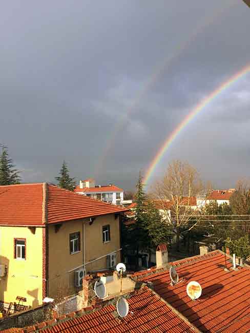  Eskişehir'de dün akşam üzeri başlayan yağışın ardından gökyüzünü renklendiren gökkuşağı vatandaşları hayran bıraktı.