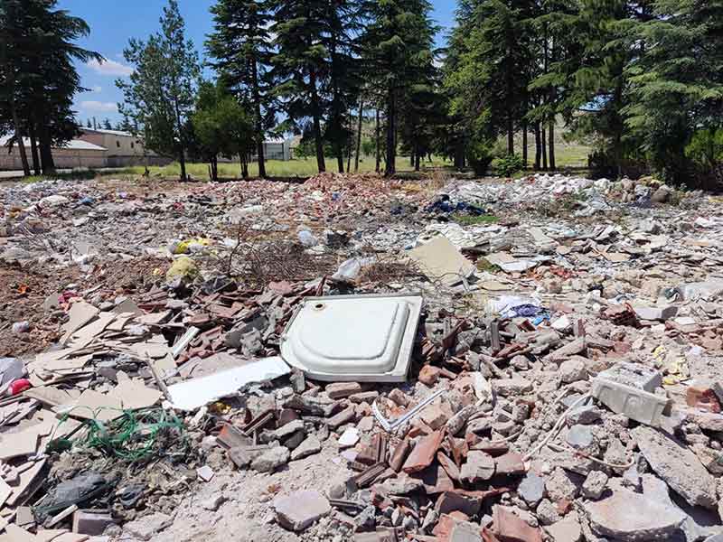Araziye dökülen çöplerin arasında ayakkabı, küvet ve ambalaj gibi ev atıkları da bulunuyor.