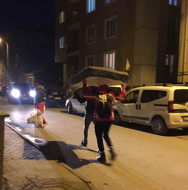  İki üniversite öğrencisi, sokak ortasında yürüyerek aldıkları baza yatağını kafalarının üstünde taşıdı