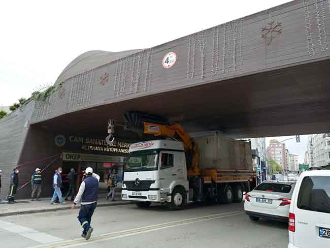 Bir lojistik firmasına ait olan kamyonun üst kısmında bulunan kanca kısmı, yüksekliği nedeniyle köprünün altından geçemedi.