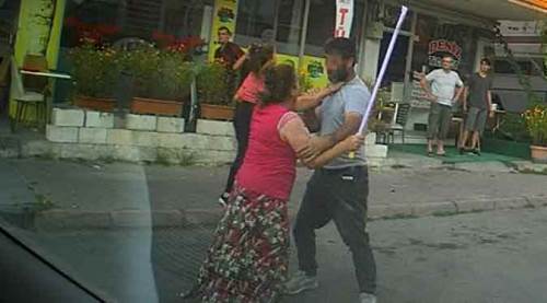 Eli sopalı kadın önüne gelen erkeği dövdü