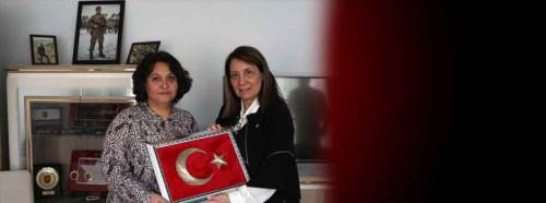 Şehit eşi için işlediği bayrağı hediye etti